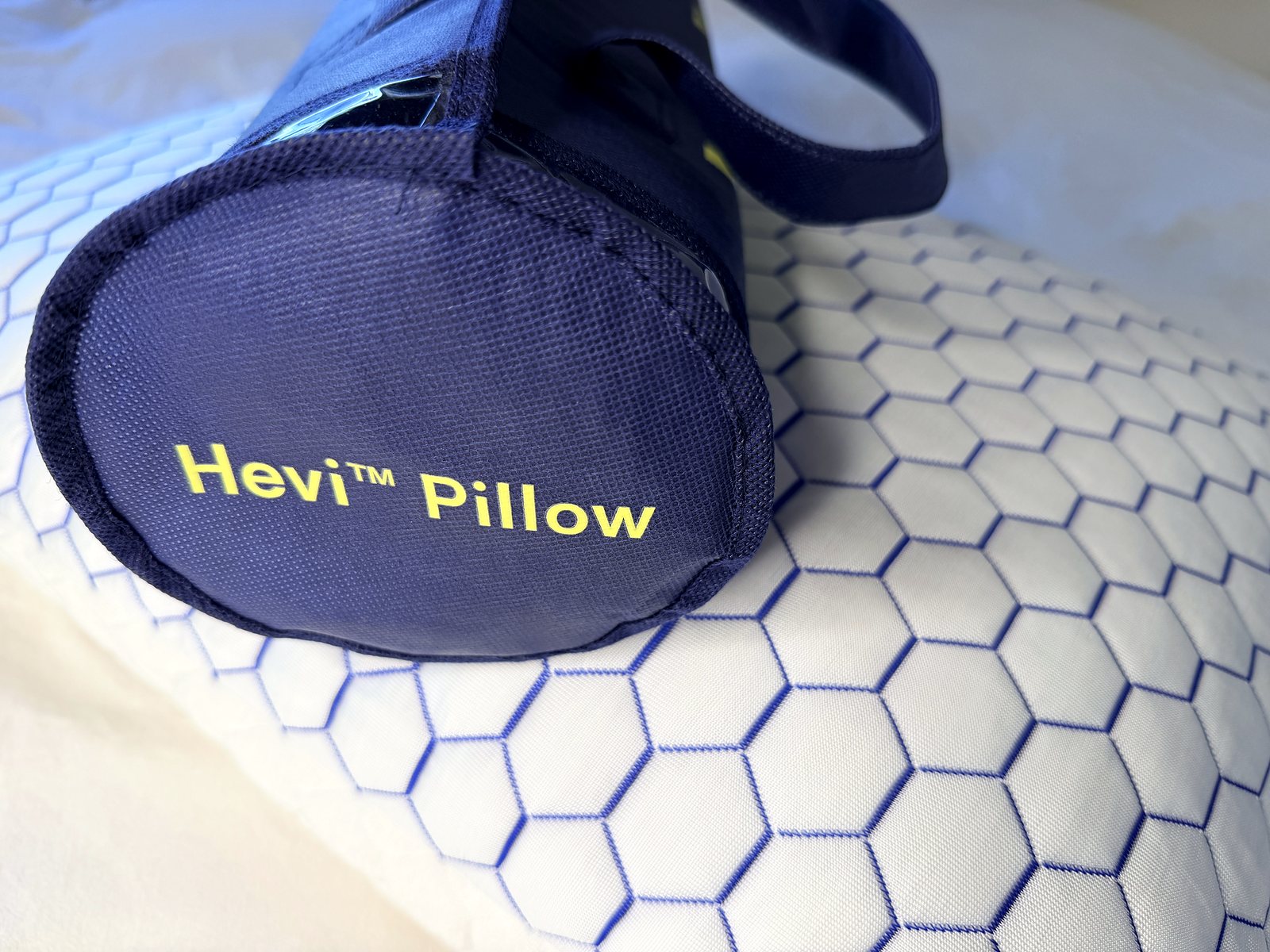 Přenosná taška Hevi Pillow položená na polštáři