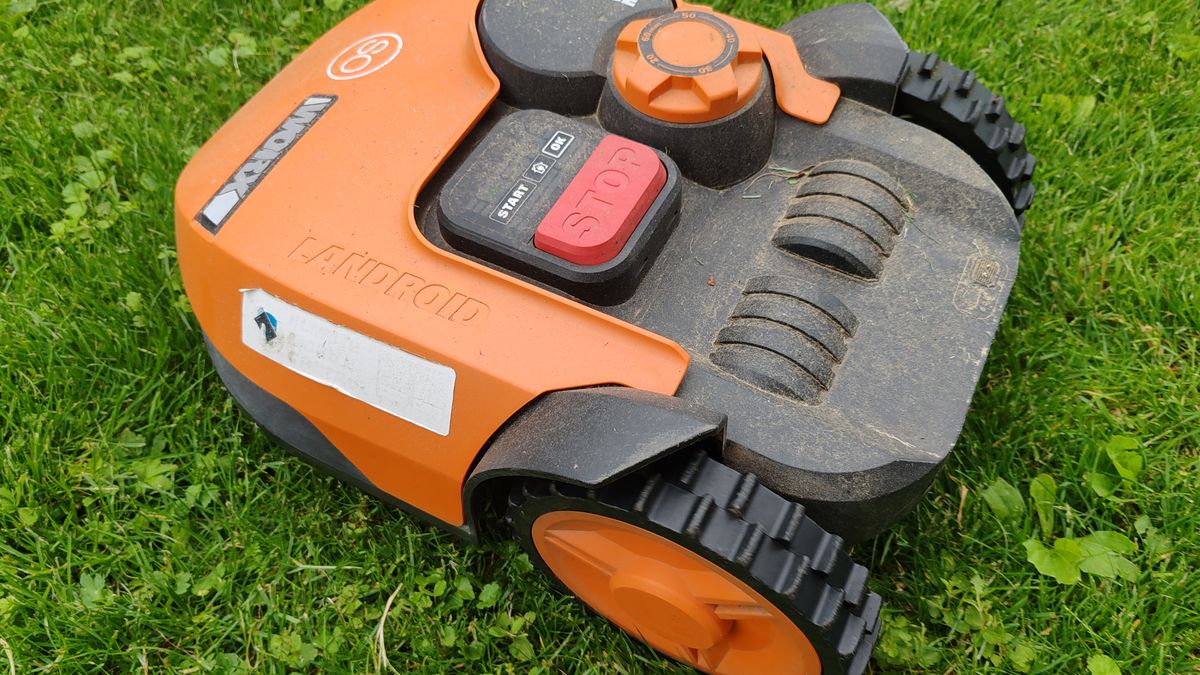 Robotická sekačka na podzimním trávníku před zazimováním
